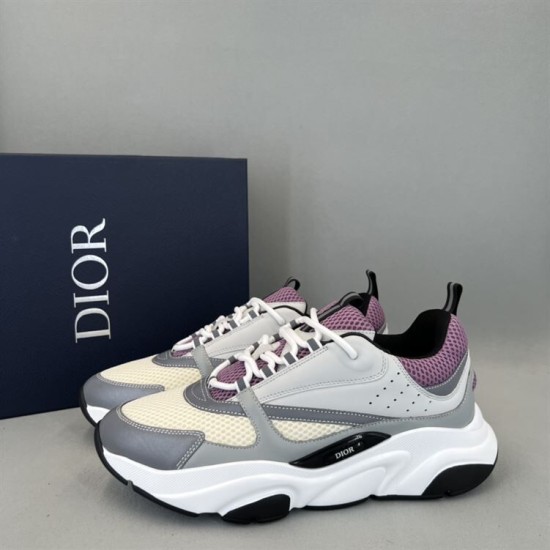 Three-quarter side angle of Dior B22 grey and purple trainers beside box
