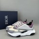 Three-quarter side angle of Dior B22 grey and purple trainers beside box