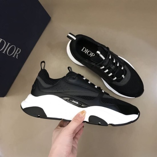 Dior B22 Black Trainer Profile Held in Hand in black and white Side profile view held in hand showing the sculpted white sole of the Dior B22 black trainer
