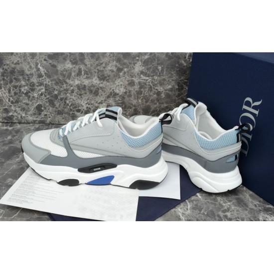 Dior B22 Trainers Side Angle in grey and white Side angled view of grey and blue mesh trainers standing together on marble background in grey and white
