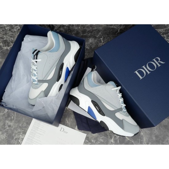 Dior B22 Trainers in Packaging in grey and white Overhead view of grey and light blue trainers sitting inside navy branded shoe box in grey and white