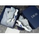 Dior B22 Trainers in Packaging in grey and white Overhead view of grey and light blue trainers sitting inside navy branded shoe box in grey and white