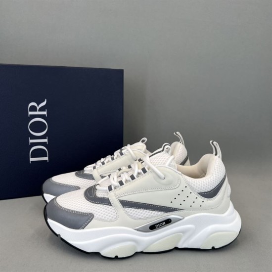 Dior B22 Trainers Pair View in white and silver Pair of Dior B22 white and silver trainers angled alongside brand shoe box
