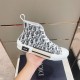 Dior B23 High-Top Canvas Trainers Handheld Side View in black and white Handheld side profile view of Dior B23 High-Top Canvas Trainers In Black And White