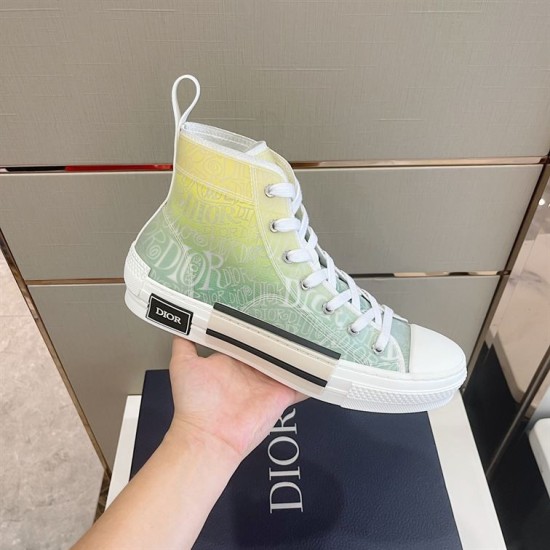 Dior B23 High-Top Trainer Side Detail in green and yellow Hand holding Dior B23 trainer showing green and yellow gradient pattern and side bumper detail