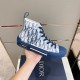 Dior B23 High-Top Oblique Canvas Blue Trainer Held Profile Side profile of Dior B23 High-Top Oblique Canvas Blue Trainer held over box