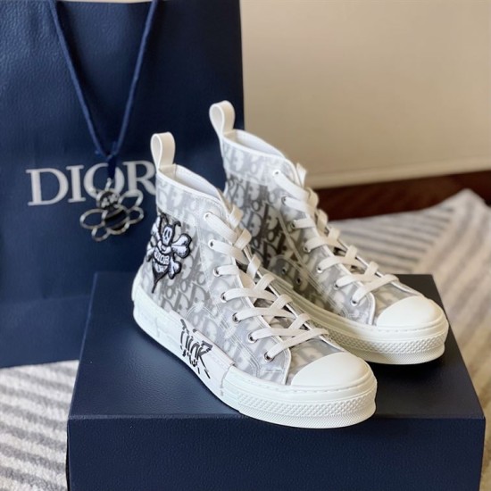 Dior B23 High-Top Trainers Three-Quarter View in white and grey Three-quarter front angle of Dior B23 trainers with packaging bag in white and grey