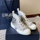 Dior B23 High-Top Trainers Three-Quarter View in white and grey Three-quarter front angle of Dior B23 trainers with packaging bag in white and grey