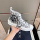 Dior B23 High-Top Trainer Handheld View in white and grey Hand holding single Dior B23 high-top trainer in white and grey monogram