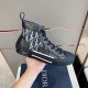 In-Hand Lateral View of Dior High-Top Trainer in grey and white Hand holding dark grey Dior high-top Oblique trainer showing lateral side details in grey and white