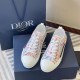 Dior B23 Low-Top Multicolour Trainers Pair View in multicolour and white Angled front view of Dior B23 multicolour trainers with white laces beside navy packaging