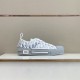 Lateral side view of white and grey Dior B23 low-top trainer showing branded side rubber panel