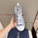 Handheld top view of Dior B23 low-top trainer showing white laces and inner lining in blue and pink