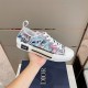 Handheld view of Dior B23 low-top trainer showing side panel and blue pink floral print