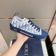 Hand holding a Dior B23 low-top trainer showcasing outer side details and sole in blue