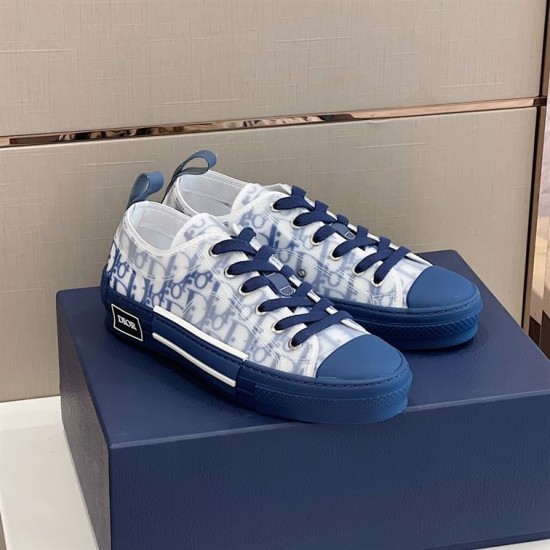 Three-quarter side angle of Dior B23 trainers resting together on packaging in blue