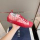 Handheld lateral view highlighting the red rubber midsole and logo plaque