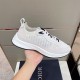 Dior B25 Runner Monogram Low Top White Trainers Handheld Side View Hand holding white Dior B25 Runner trainer showing lateral monogram pattern panel