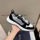 Dior B25 Runner Handheld Side View in black and white Hand holding black and white Dior B25 Runner trainer showing side oblique panel