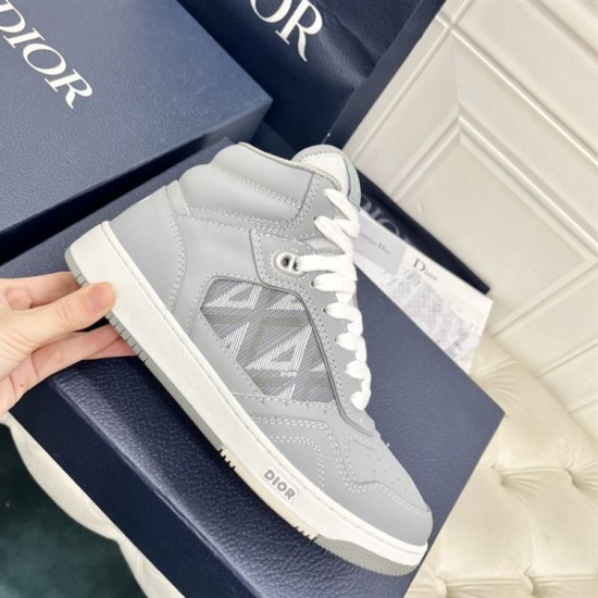 Dior B27 High-Top Grey Canvas Trainer - Handheld Side View in grey and white Handheld lateral view of Dior B27 high-top grey trainer showcasing leather panelling and stitching in grey and white