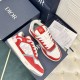 Pair of Dior B27 low-top trainers in red and white leather set against product packaging