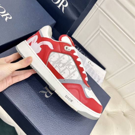 Handheld lateral view of Dior B27 Red White Leather Trainer displaying Oblique canvas insert and heel graphic