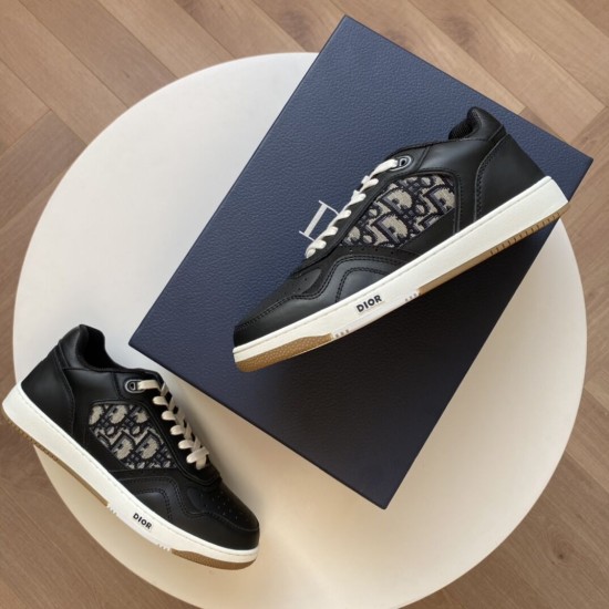 Dior B27 black leather low-top trainers displayed beside blue packaging box in black and white