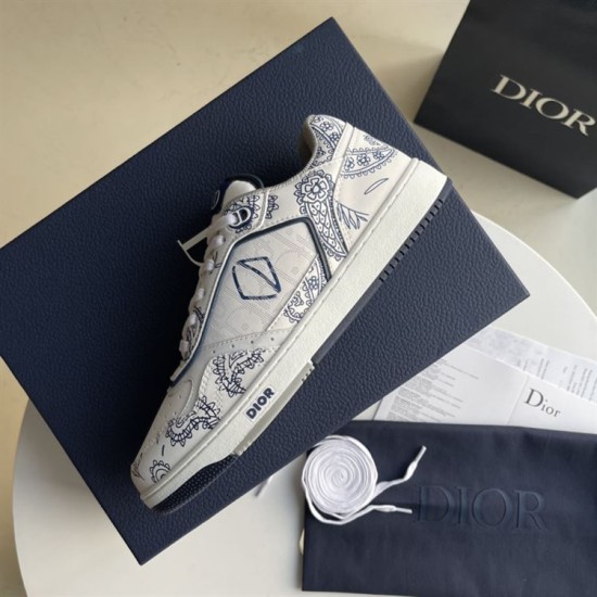 Side profile of Dior low-top paisley trainer resting on blue shoe box in white and navy