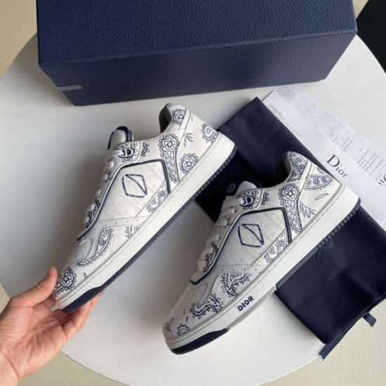 Pair of Dior white and navy paisley print trainers on display surface