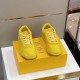 Pair of yellow Dior B27 low-top trainers resting on branded yellow shoe box