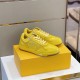 Angled front view of yellow Dior B27 trainers on shoe box