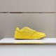 Dior B27 low-top yellow trainer standing on display surface