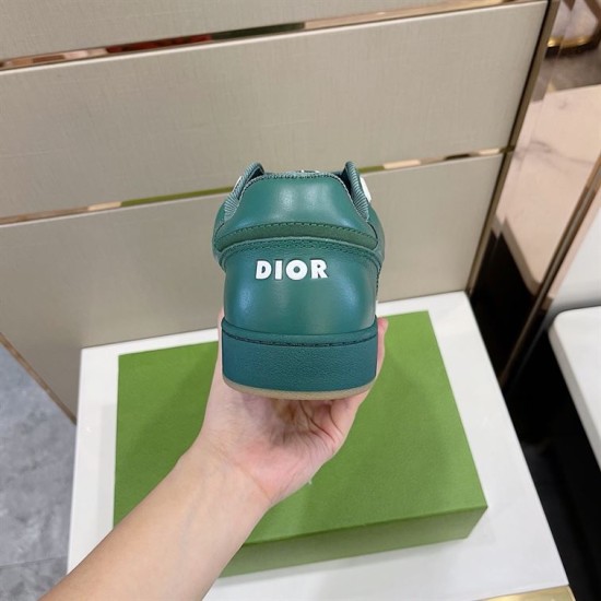 Rear heel view of green Dior B27 low-top trainer held up in hand in green and white