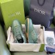 Pair of green Dior B27 trainers in open shoe box with packaging and shopping bags in green and white