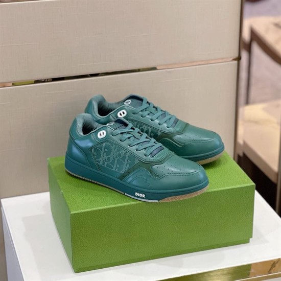 Three-quarter side angle view of green Dior B27 low-top trainers on box in green and white