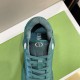Close-up top view of green Dior B27 trainer tongue, eyelets, and laces in green and white