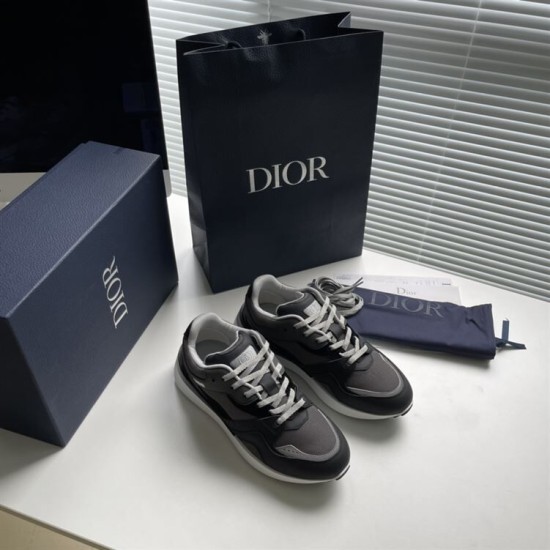 Dior B29 trainers alongside branded blue box and shopping bag in grey and black