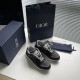 Dior B29 trainers alongside branded blue box and shopping bag in grey and black