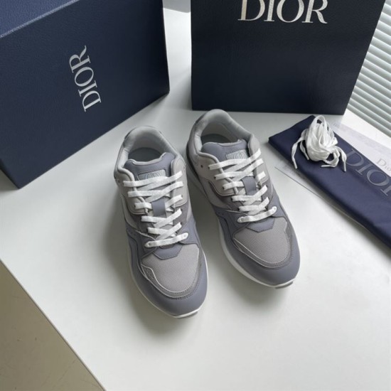 Pair of Dior grey low-top mesh trainers arranged alongside a dust bag and branded box in grey and white