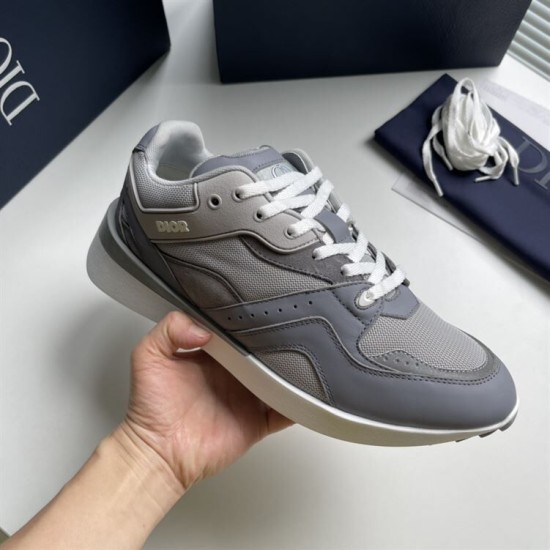 Angled hand view showing the toe box and side panel of the grey Dior trainer in grey and white
