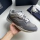 Angled hand view showing the toe box and side panel of the grey Dior trainer in grey and white