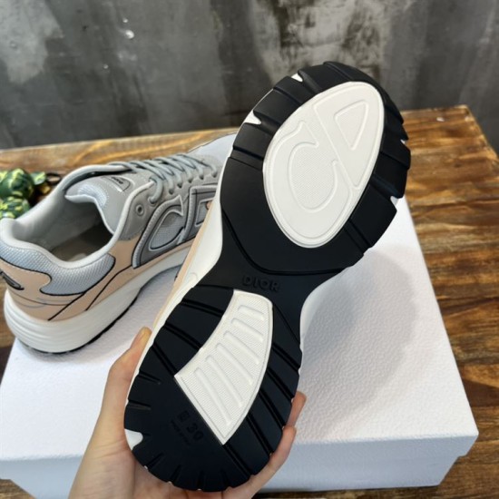 Underside of Dior B30 trainer showing black rubber sole and CD branding in grey and pink