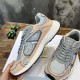 Hand holding Dior B30 grey and light pink trainer showing side profile