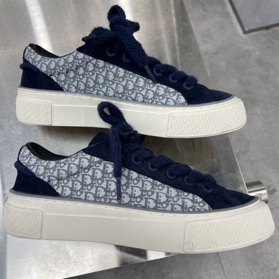 Pair of Dior B33 navy blue trainers stacked showing lateral sides and thick cream soles