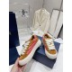 Dior B33 Trainer Lateral View in brown and red Side profile of Dior B33 Striped Canvas And Suede Low Top Trainer held near the box in brown and red