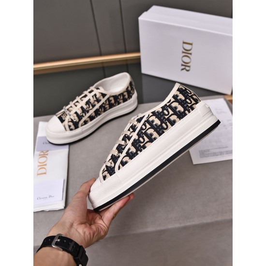 Hand holding a Dior navy blue oblique canvas platform trainer showing side sole detail
