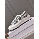 Lateral side view of Dior Walk'n'dior platform trainer resting on a white display box in white and black