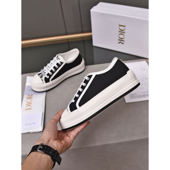 Dior Platform Trainer Handheld Perspective in black Hand holding a Dior black canvas platform low-top trainer