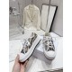 Hand holding a Dior Walk'n'dior platform trainer showing the side signature trim in beige