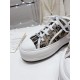 Close-up view of the white toe cap, laces, and printed canvas upper on Dior trainers in beige